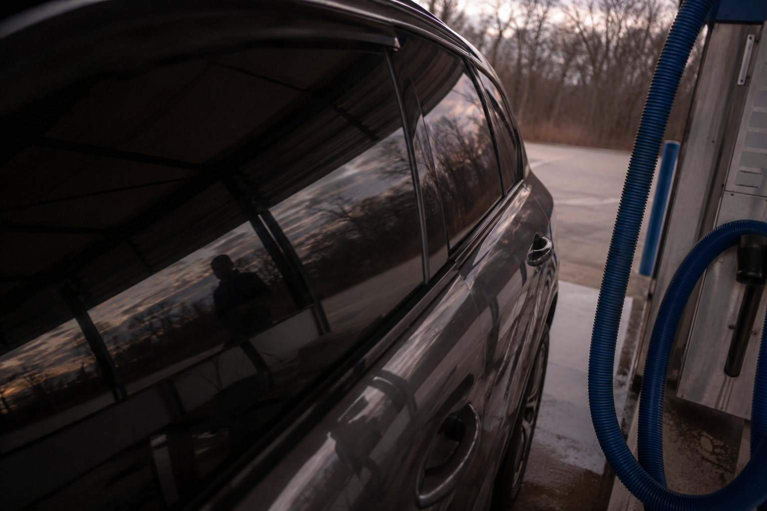 Passenger-shaped silhouette reflected near car wash vacuum station