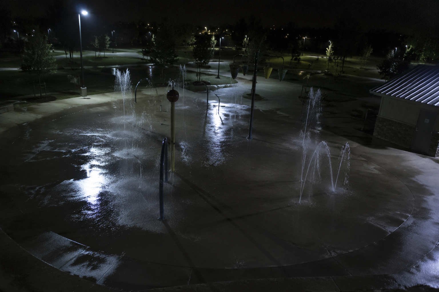 Water jets pulsing once on empty splash pad camera
