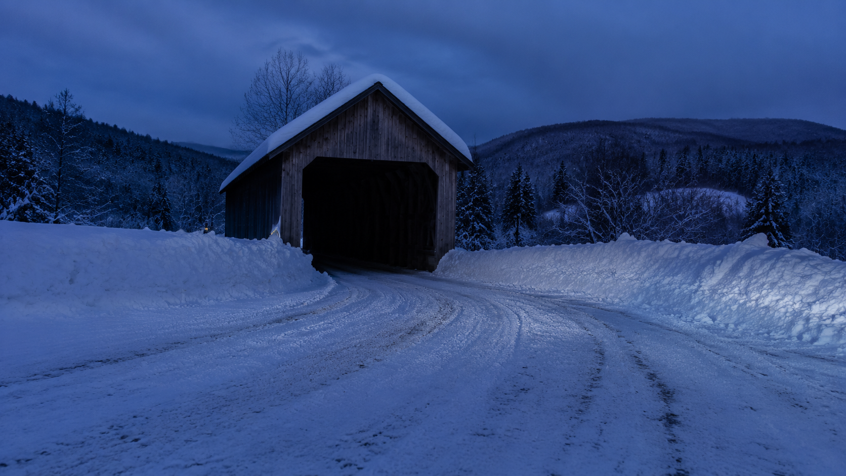 Remote covered bridge beside a snowy plow turnaround