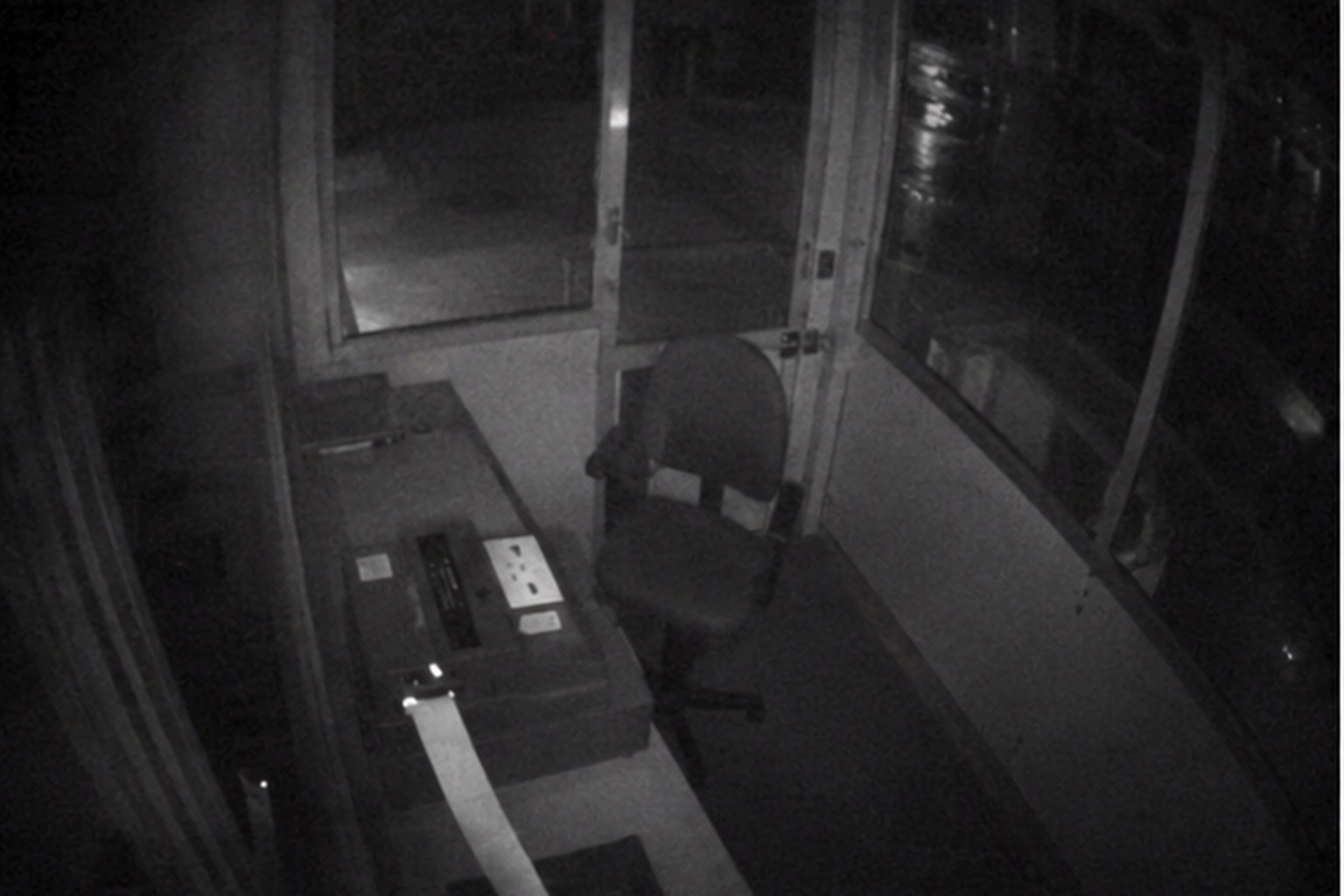 The camera did not show a customer at the window, only the booth glass flashing with dark water behind it.