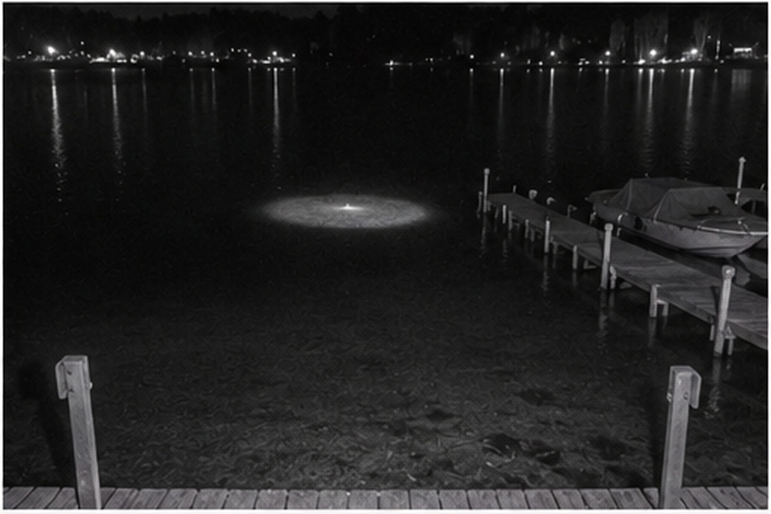 Pale disc hovering above a lake dock at night