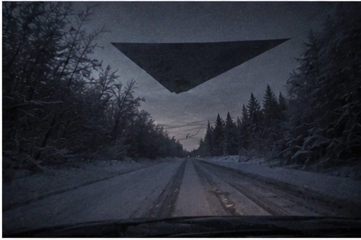 Huge dark triangle over an icy rural road