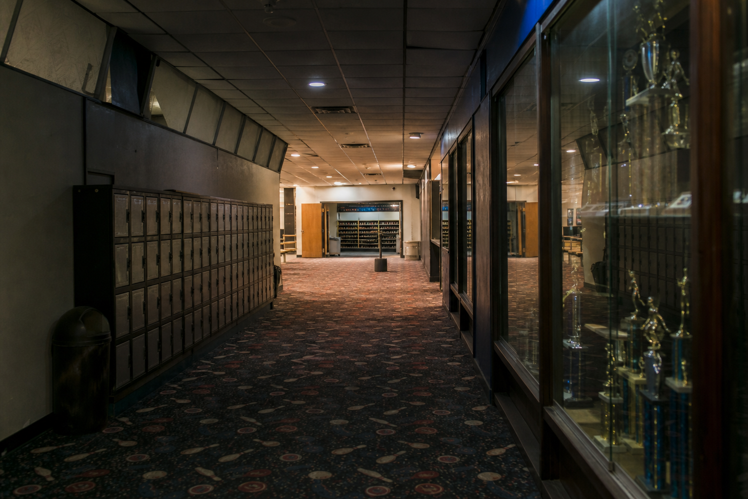 Closed bowling alley corridor with empty hallway reflected in trophy glass