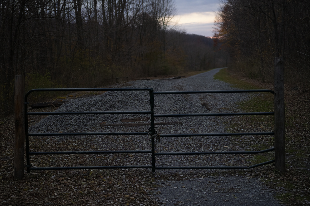 Locked rail-trail gate with fresh gravel beyond it