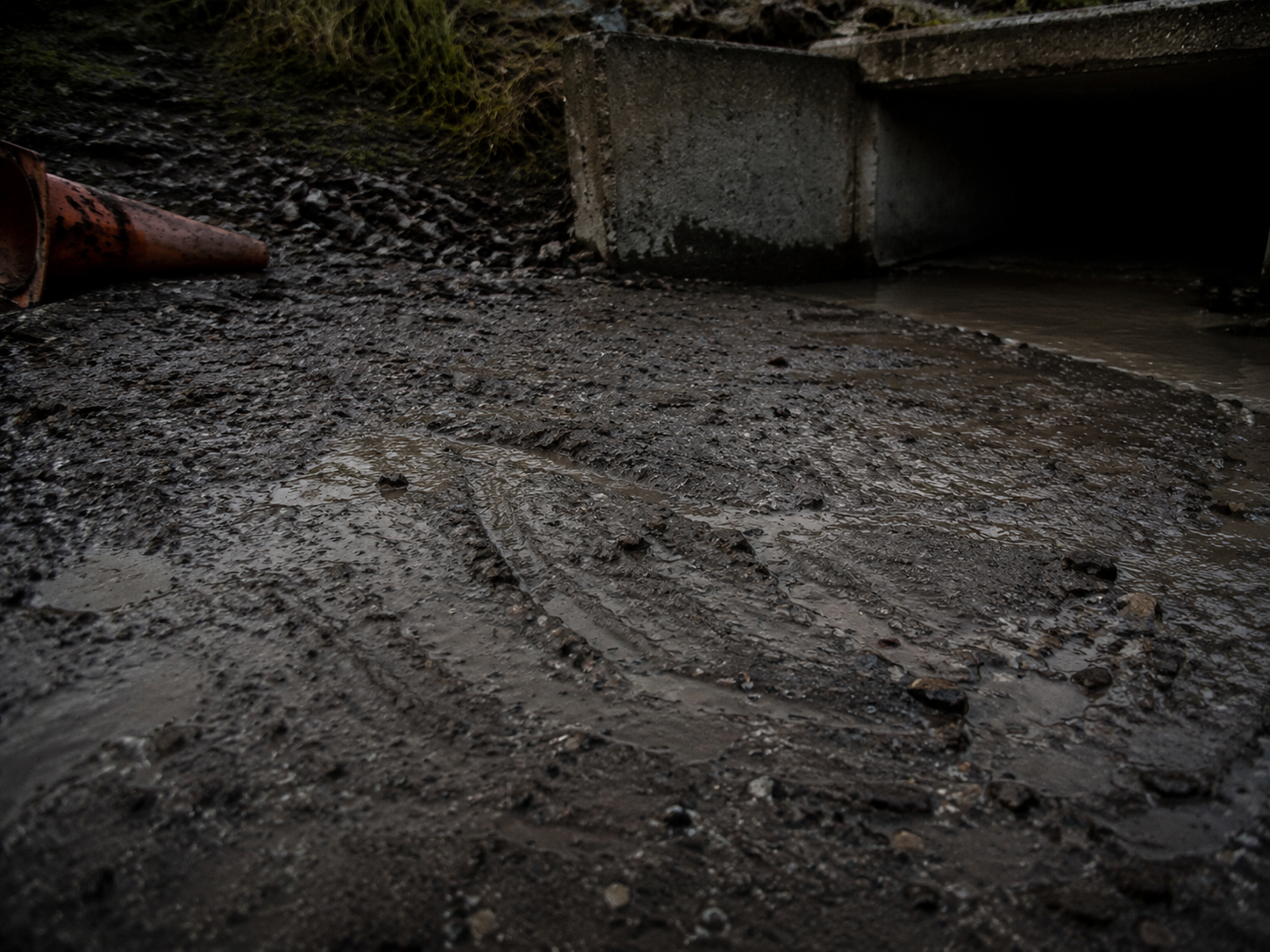 Wet scrape marks near concrete culvert