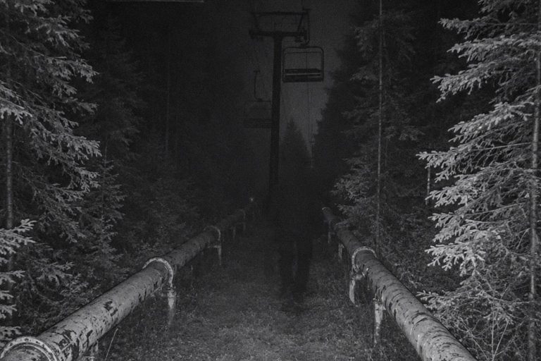 Editorial recreation of the Abandoned Ski Lift Trail Camera Showed A Massive Shape Between The Snowmaking Pipes story, image 1.