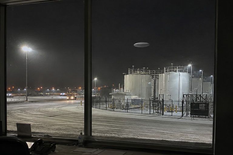 Editorial recreation of the Airport Baggage Claim Window Camera Caught A Silent Silver Oval Above The Deicing Tanks story, image 1.