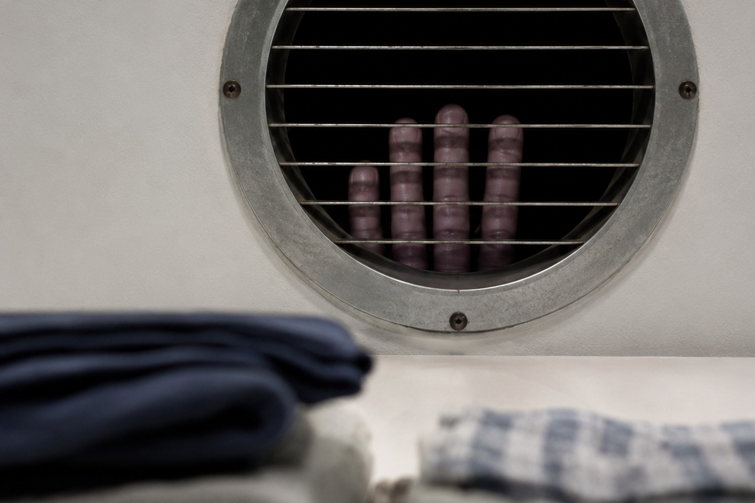 Editorial recreation of the Closed Coin Laundry Folding Table Photo Showed Fingers Pressed Through The Dryer Vent story, image 4.