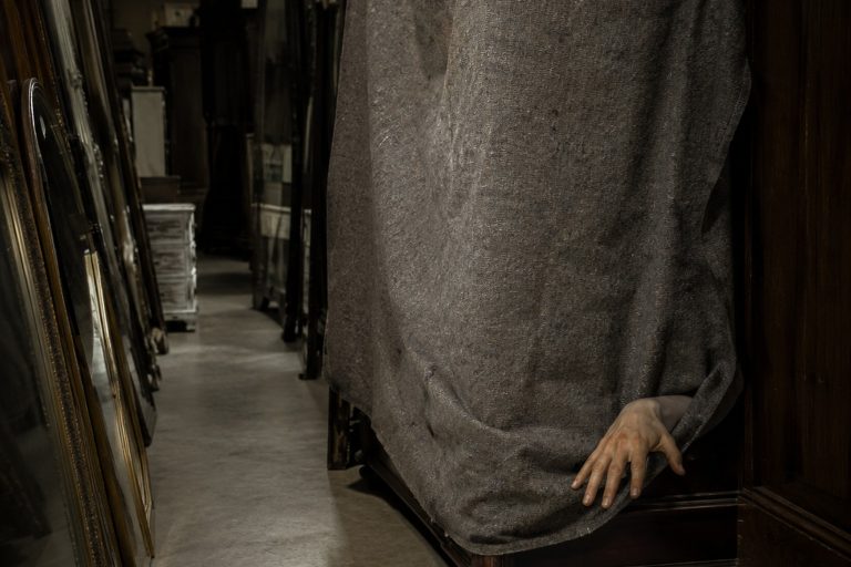 The Closed Thrift Store Mirror Aisle Camera Showed A Hand Reaching From Behind A Covered Wardrobe reconstructed scene image 1