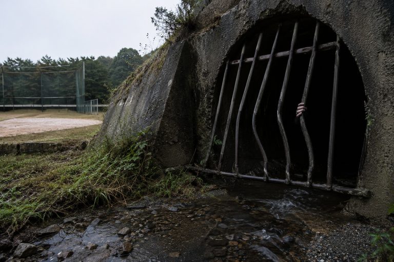 Editorial recreation of the Drainage Tunnel Camera Saw A Pale Hand Reaching Around The Bent Warning Bars story, image 1.
