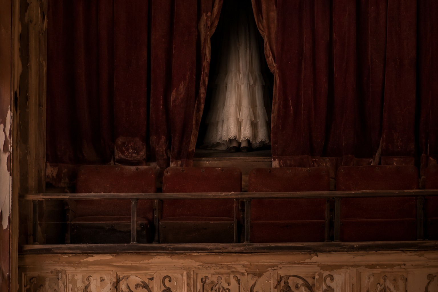 Editorial recreation of the Empty Community Theater Balcony Photo Showed A White Dress Behind The Torn Curtain story, image 2.