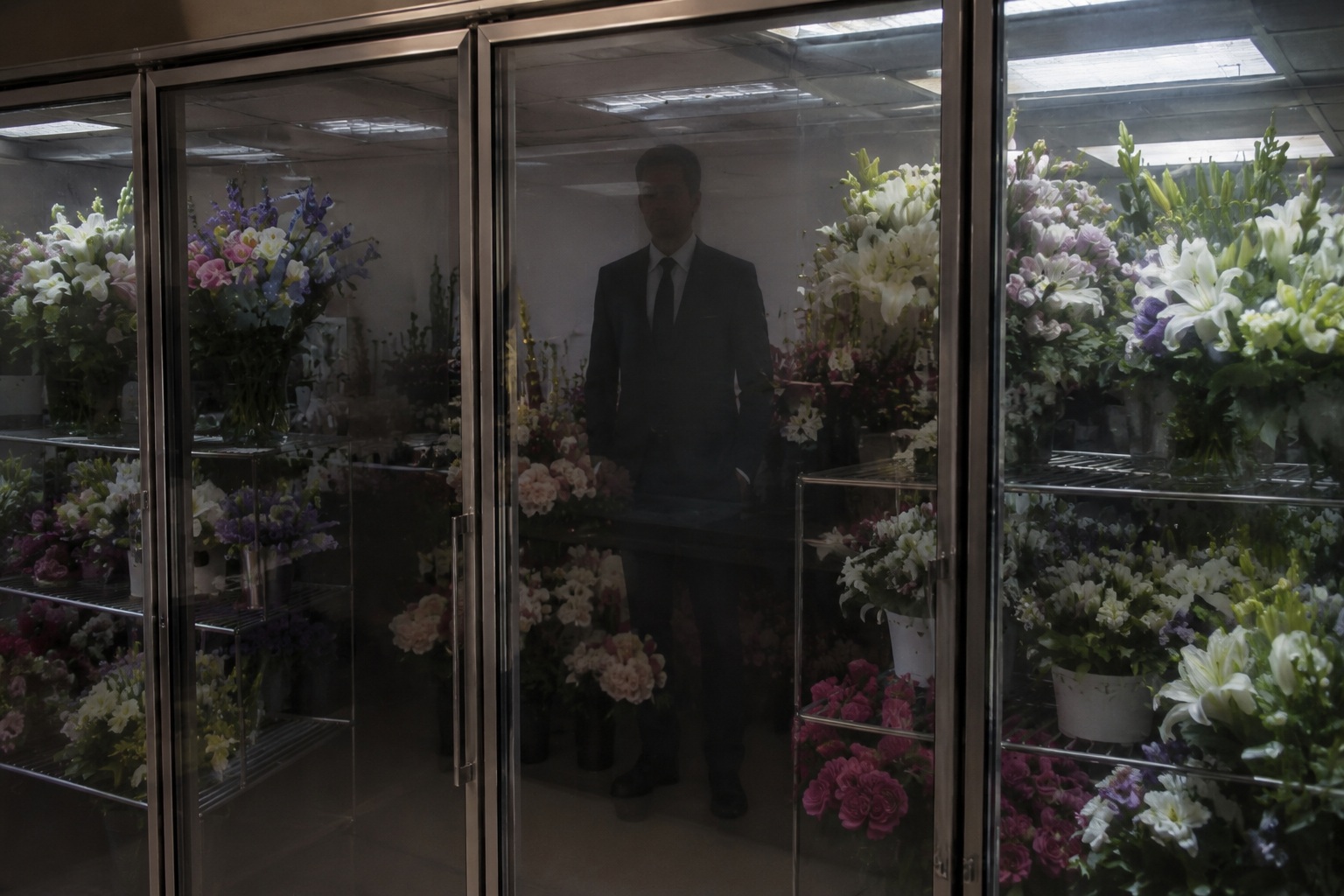 Editorial recreation of the Funeral Home Flower Room Camera Showed A Man In A Dark Suit Behind The Refrigerated Case story, image 2.