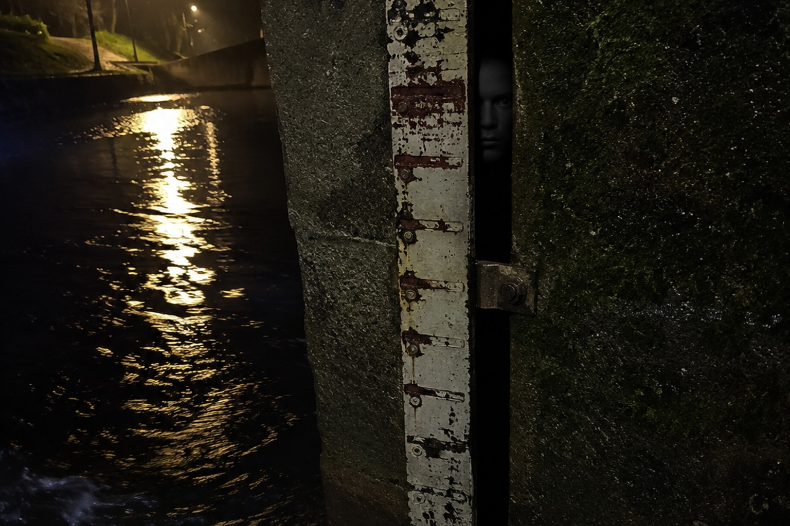 Editorial recreation of the Night Walk Photo On The Canal Footbridge Showed A Face Behind The Flood Gauge story, image 1.